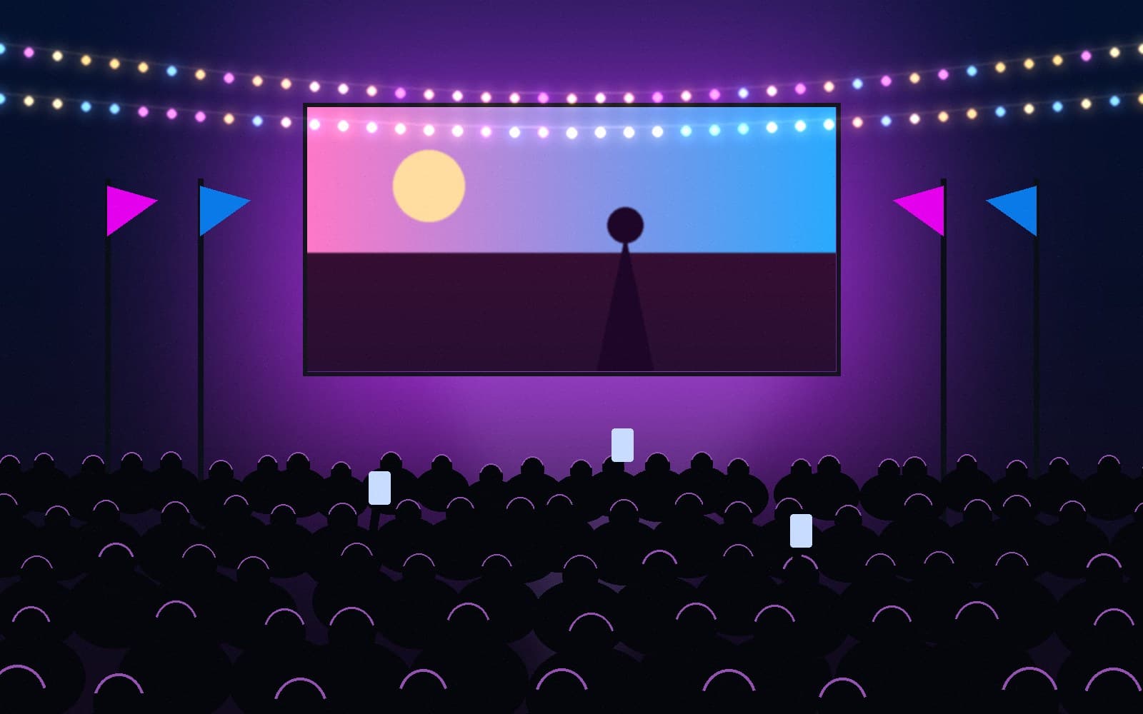 A festival audience watching an open-air screening under string lights